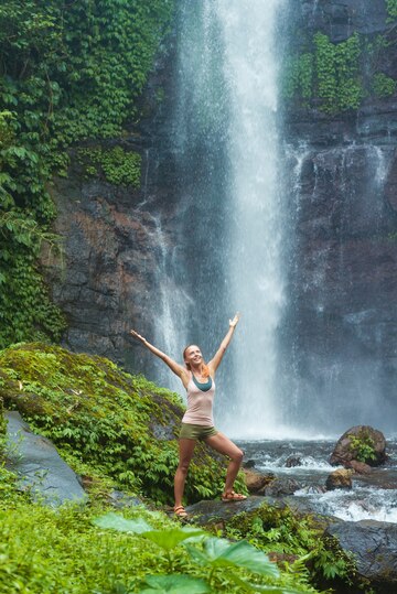 young-woman-practicing-yoga-by-waterfall_1385-1798